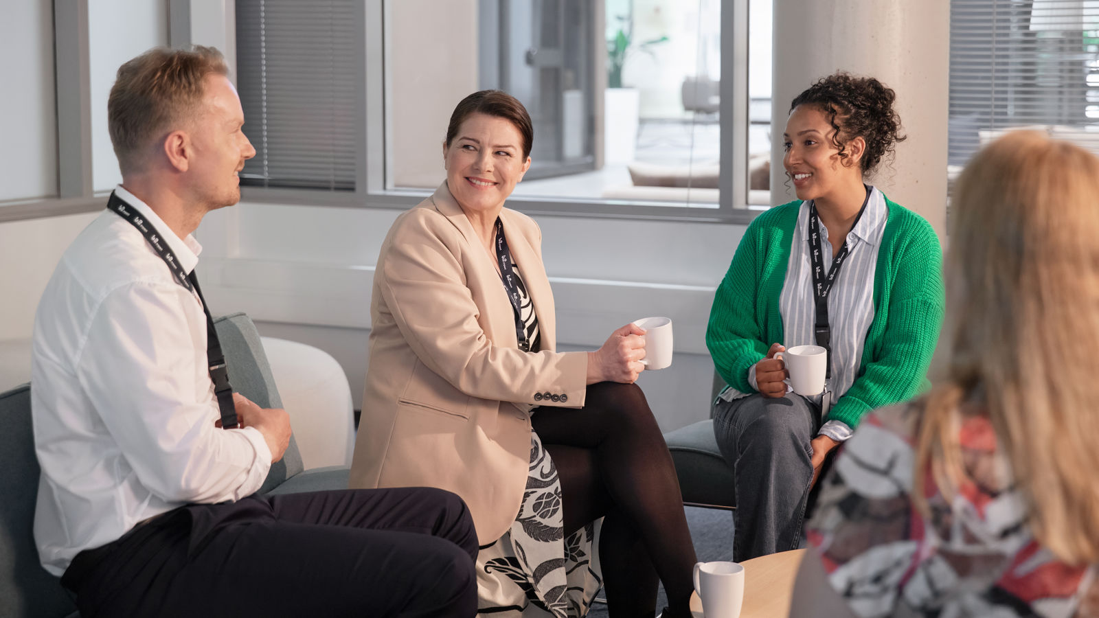 Two women and a man talking in a lounge